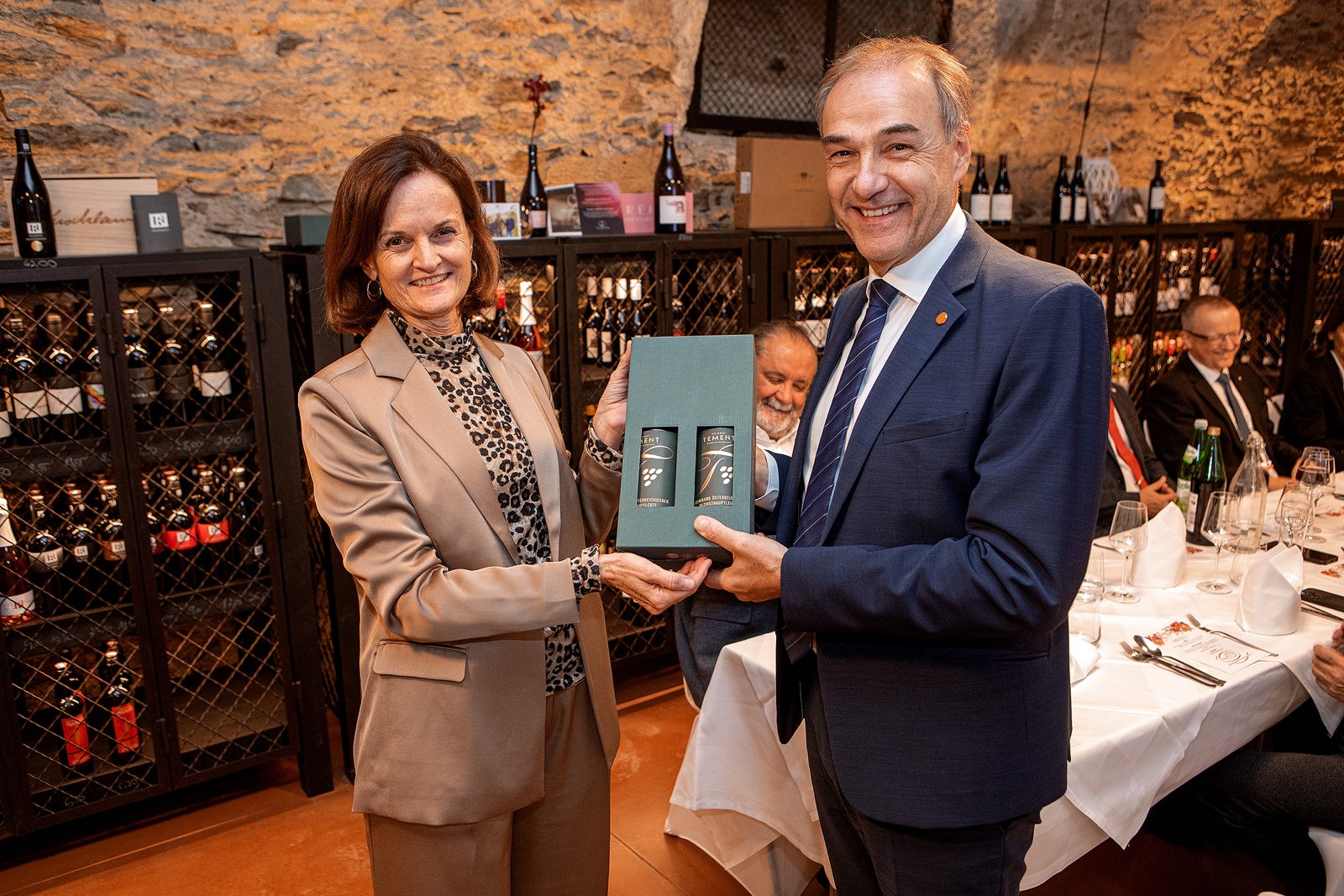 Vorsitzende Martina Gerersdorfer, Bezirkshauptfrau von Amstetten, überreicht Landesrat Leonhard Schneemann ein Präsent in der Weinkosterei der Burg Schlaining