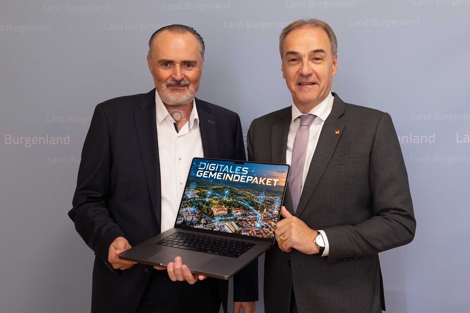 LH Hans Peter Doskozil und LR Leonhard Schneemann präsentieren das Digitale Gemeindepaket des Landes Burgenland auf einem Laptop